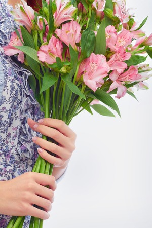 Close-up of bunch of pink lilies in female handsの写真素材