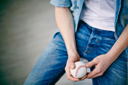 Hands of guy in jeans holding tennis ballの写真素材
