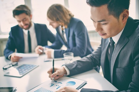 Portrait of a businessman in board room analyzing charts の写真素材