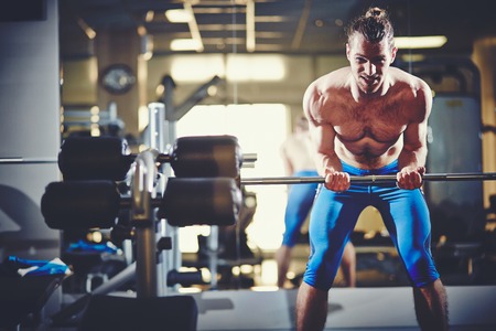 Portrait of sporty topless man with weight looking at camera 