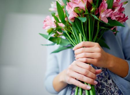 Close-up of bunch of fragile lilies in female handsの写真素材