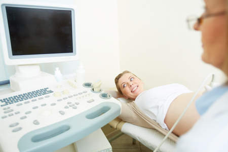 Happy young woman undergoing regular examination at hospitalの写真素材