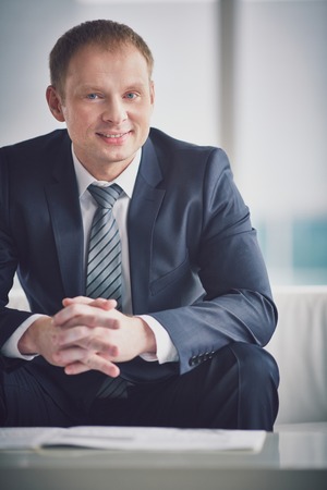 Smiling businessman in suit looking at camera