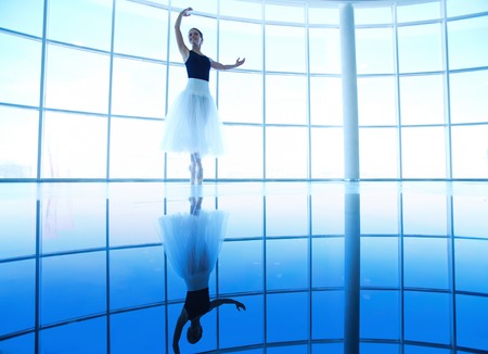 Image of young ballerina keeping balance while training in gymの写真素材