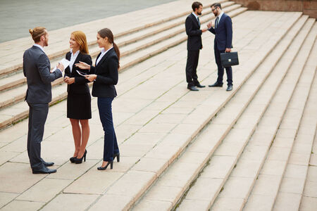 Two small groups of business people interacting outside
