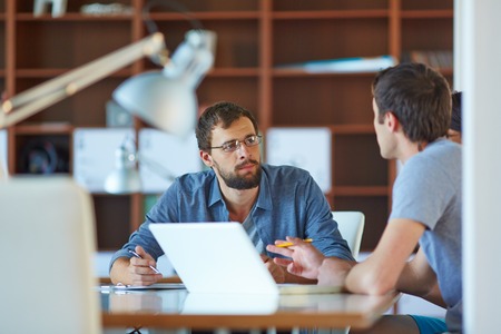 Two businessmen interacting at meeting in officeの写真素材