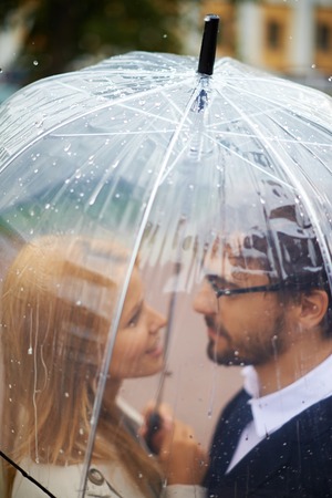 Portrait of affectionate couple under umbrella outside