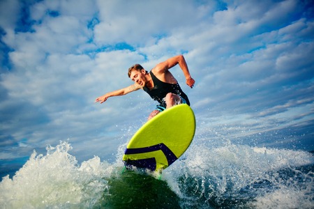 Male surfer riding on board in summerの写真素材
