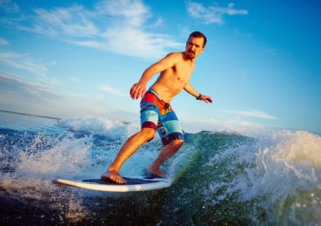 Young man surfboarding in summerの写真素材