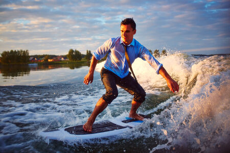 Active young man surfboarding at summer resortの写真素材