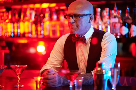 Bald male in eyeglasses waiting for clients in the barの写真素材