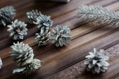 Several decorative silver cones and conifer on wooden の写真素材