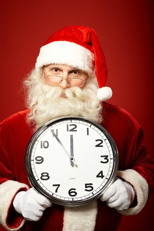 Santa Claus holding clock while warning that xmas is in five minutesの写真素材