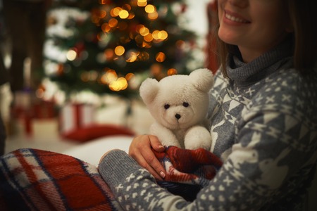 Young female with teddy bear having rest at homeの写真素材