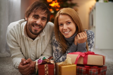 Cheerful couple looking at camera with smiles on holiday eveningの写真素材