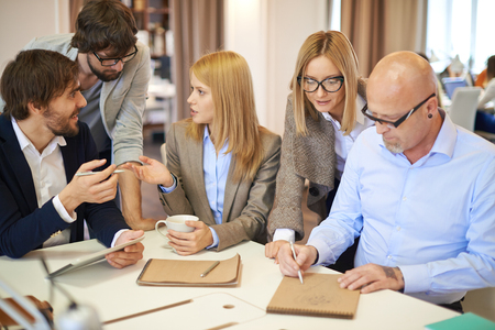 Group of modern designers interacting at meeting in officeの写真素材