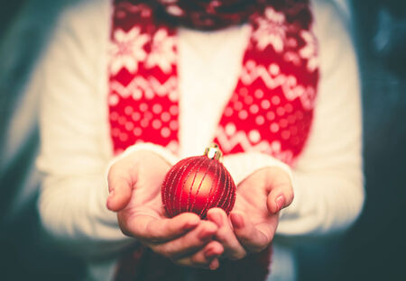Decorative red xmas toy ball on female palmsの写真素材
