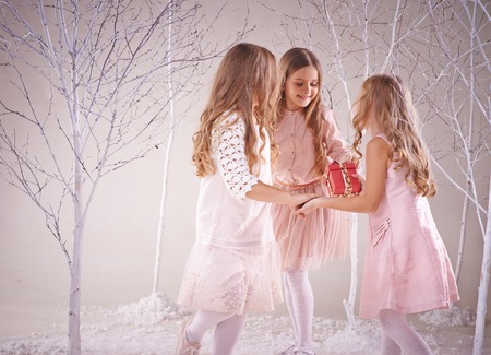 Cute playful girls dancing in fairy winter forestの写真素材