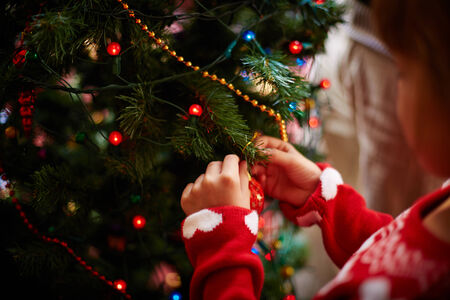 Little girl decorating firtree with toy bubblesの写真素材
