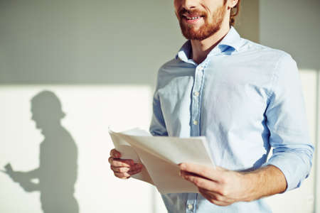 Smiling businessman with documentsの写真素材