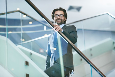 Mature businessman in elegant suit and eyeglasses looking at cameraの写真素材