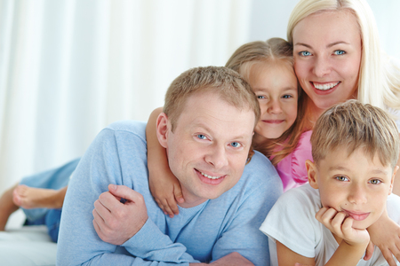 Happy young couple and their children looking at cameraの写真素材