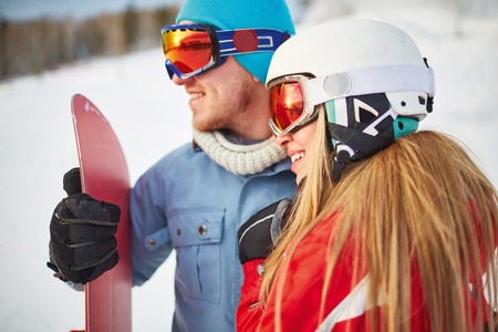 Young female and male snowboarders in winter activewearの写真素材