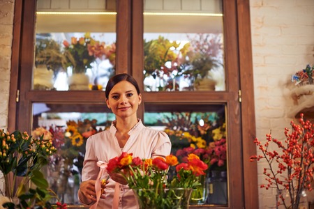 Portrait of a friendly girl at the counter of flower shopの写真素材