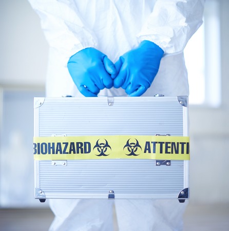 Close-up of medical case with biohazard symbol in scientist gloved handsの写真素材