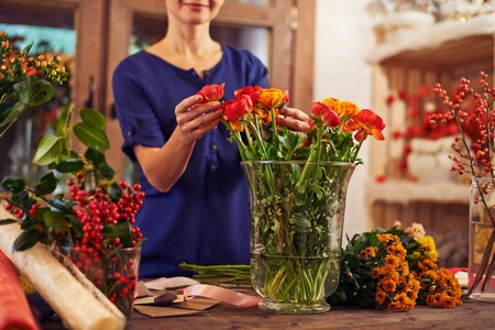 Flower seller putting flowers into a vaseの写真素材