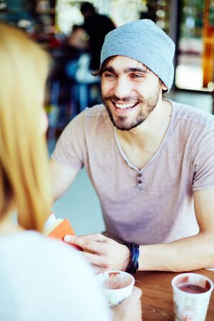 Happy guy looking at his girlfriend while talking to herの写真素材