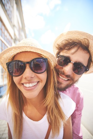 Happy couple looking at camera in urban environmentの写真素材