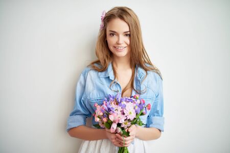 Charming girl in casualwear holding fresh bouquetの写真素材
