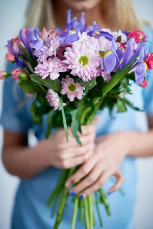 Bouquet of various spring flowers held by girlの写真素材