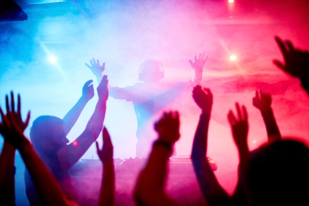 Male deejay in front of dancing crowd