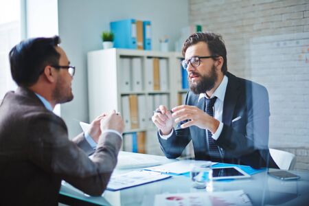 Elegant businessmen communicating at meeting