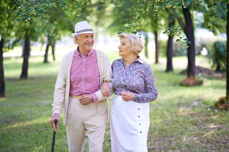 Elegant seniors taking a walk in the park in summerの写真素材
