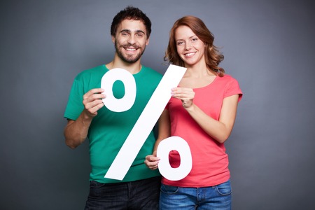 Affectionate couple showing percentage symbolの写真素材