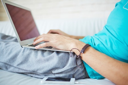 Young man typing while having restの写真素材