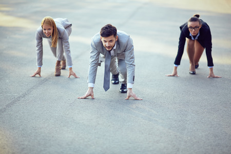 Three businesspeople ready to run