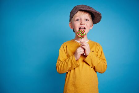 Boy licking lollipopの写真素材