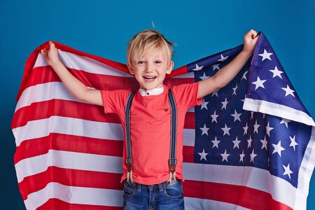 Little boy cheering with American flagの写真素材