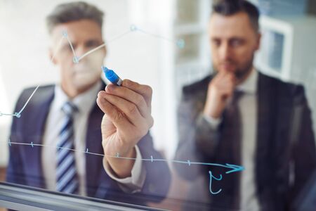 One man explaining graph to another person