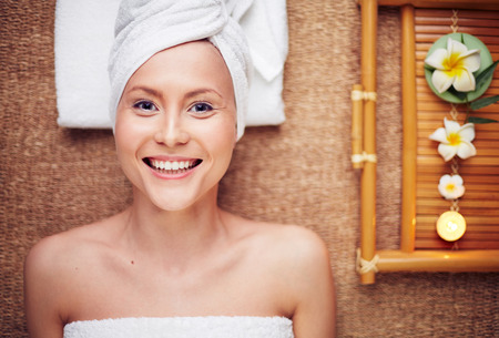 Woman lying on massage table and smilingの写真素材