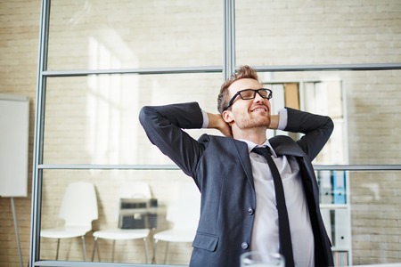 Young businessman having a little rest after work in officeの写真素材
