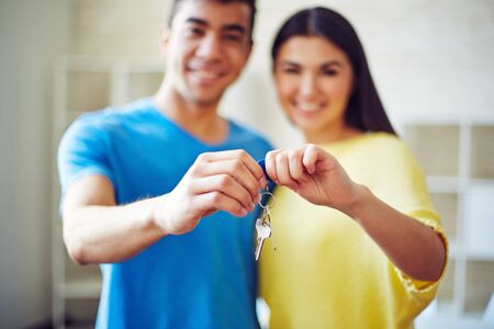 Young couple showing key from their new residenceの写真素材