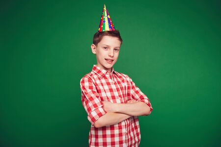 Happy kid with birthday cap looking at camera