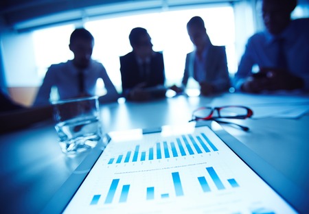 Business document with charts on background of working business teamの写真素材