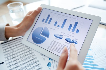 Marketing data in digital tablet and female hand over itの写真素材