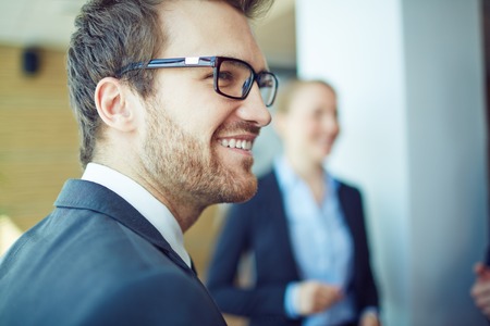Smiling businessman in eyeglasses on background of womanの写真素材